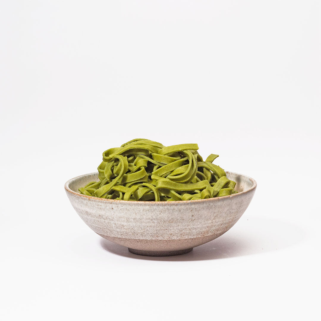 Hover image of a Ballehage collection dinner bowl filled with pesto pasta.