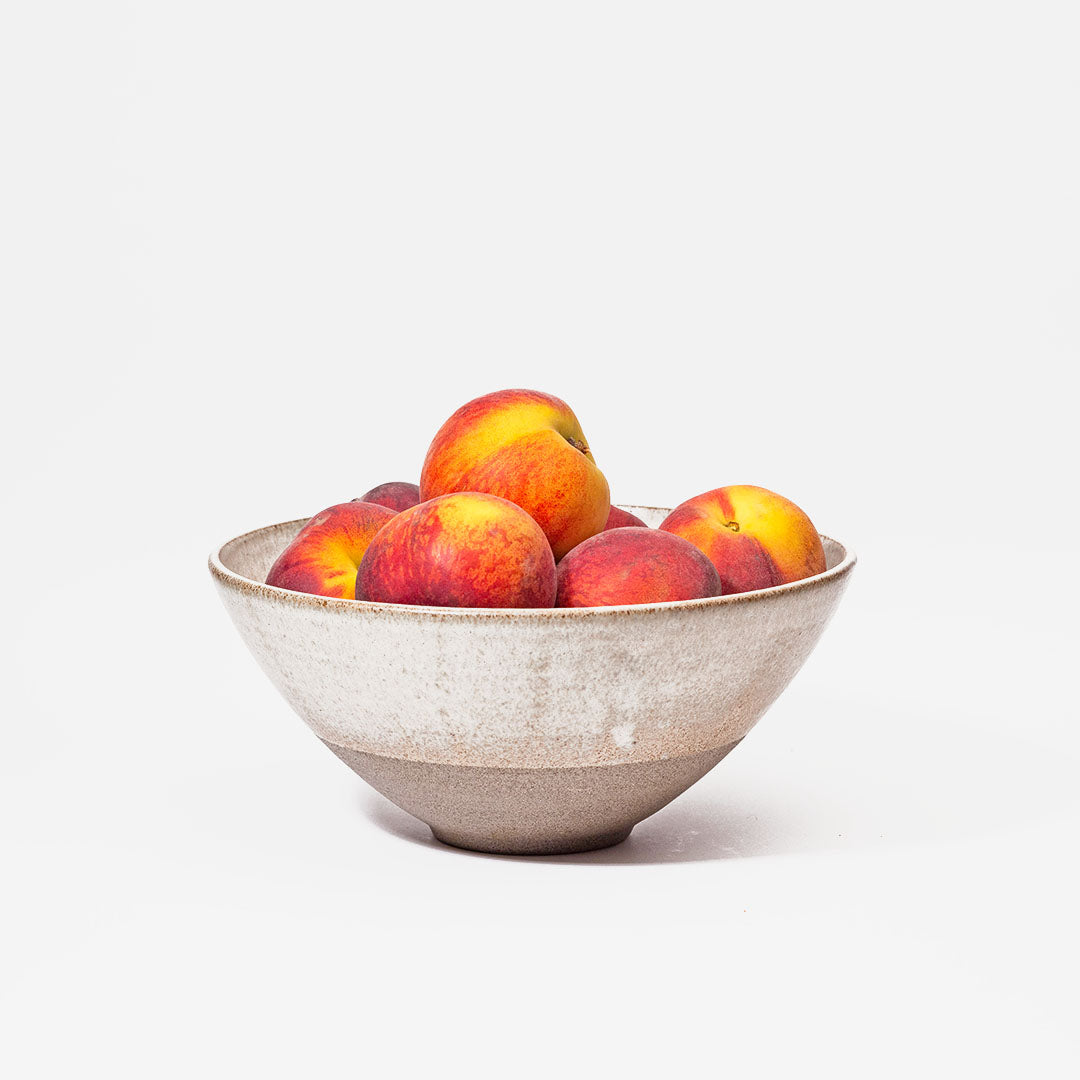 Hover image of a Ballehage collection salad bowl, filled with peaches.