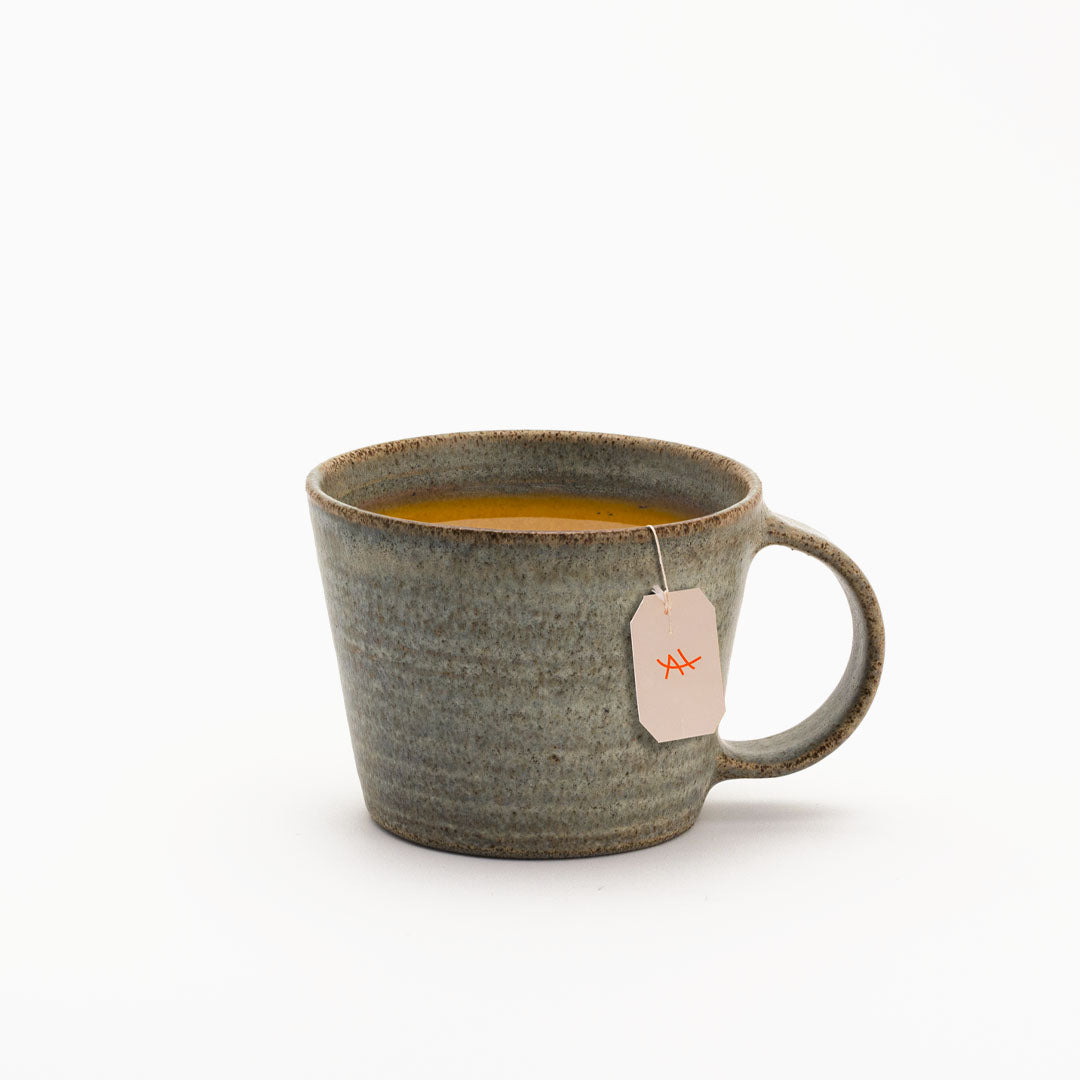 Hover image of a Ballehage collection mug, filled with tea and milk.