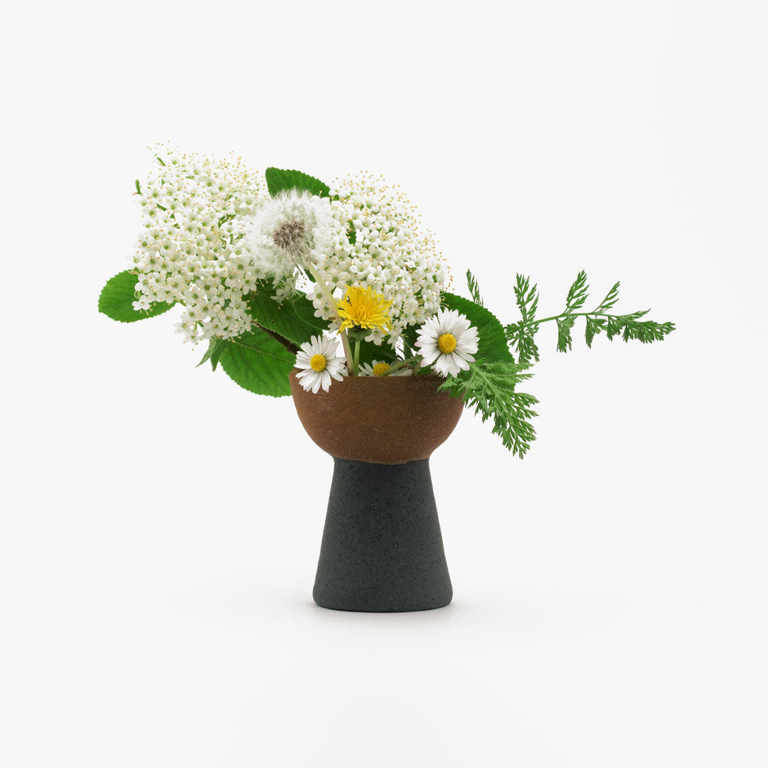 Hover image of a brown and black onion vase with a flower bouquet inside.