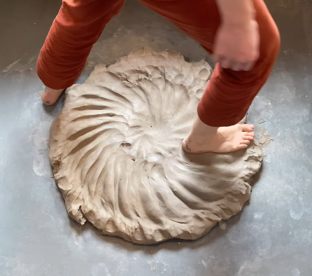 Amalie Hammershøi former ler med en japansk teknik kaldet Ram's head ved at bruge sine fødder til at ælte leret.